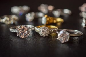 picture of jewelry: gold engagement rings on black background. 