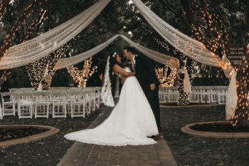 bride and groom wedding outdoor patio white lights trees canopy