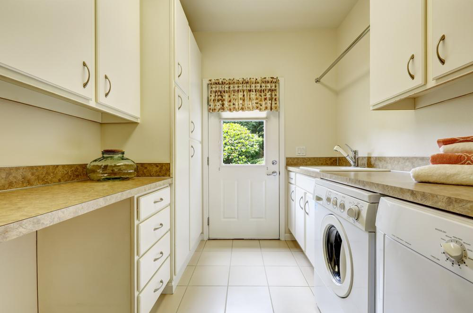 Image of a cream-colored galley laundry room with a door at the back end